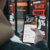 Person holding a mobile phone on Black Friday shopping. Photo: CardMapr.nl (@cardmapr)