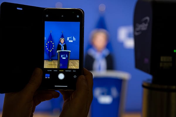 Año Nuevo, nuevo “paquete” de ciberseguridad de la Comisión para 2021. La presidenta de la Comisión Europea, Ursula von der Leyen, en el podio vista a través de un teléfono móvil. Foto: Lukasz Kobus – EC Audiovisual Service / © European Union, 2020