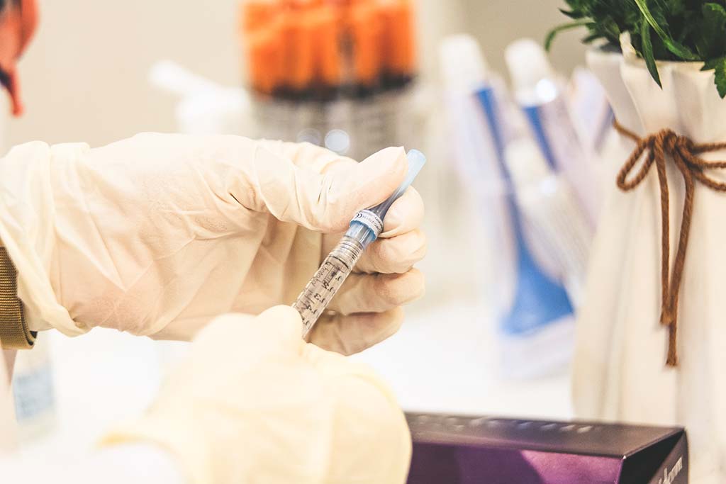 Waiving vaccine patents? Person holding a vaccine injection. Photo: Sam Moqadam (@itssammoqadam)