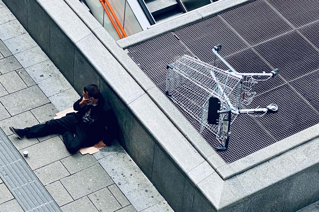 The fight against inequality. Woman in black jacket and black pants lying on gray concrete stairs in Vienna (Austria). Photo: Arno Senoner (@arnosenoner). Elcano Blog