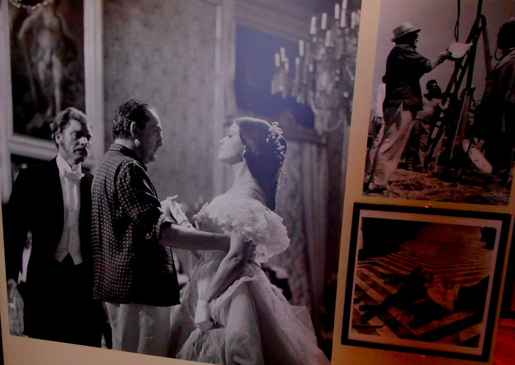Foto de la exhibición “Giuseppe Tomasi di Lampedusa (1896-1957): un lettore europeo”. Luchino Visconti dirige a Burt Lancaster y a Claudia Cardinale en la escena del baile en la adaptación cinematográfica de “El gatopardo” (1963). Foto: Carlo Raso (Dominio público).