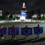 Personas portando la bandera europea frente al Castello Sforzesco (Milán, Italia) iluminado con motivo del Día de Europa 2021. Foto: Piero Cruciatti/©European Union, 2021. EC-Audiovisual Service. Blog Elcano