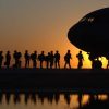 Soldados en fila para subir a un avión.