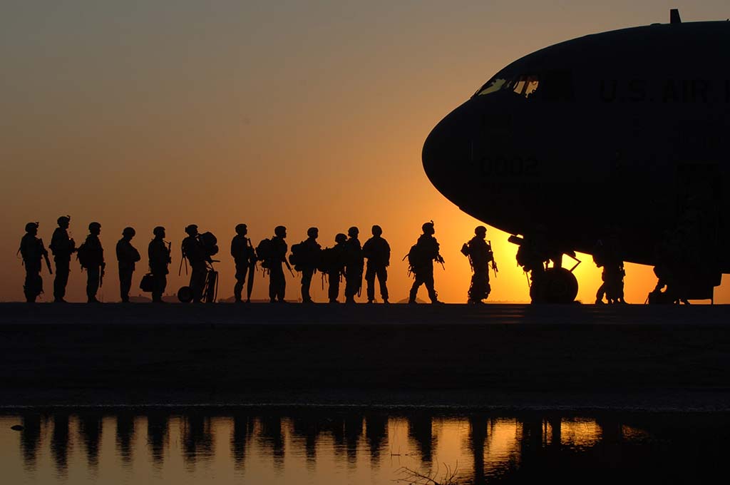 Soldados en fila para subir a un avión.