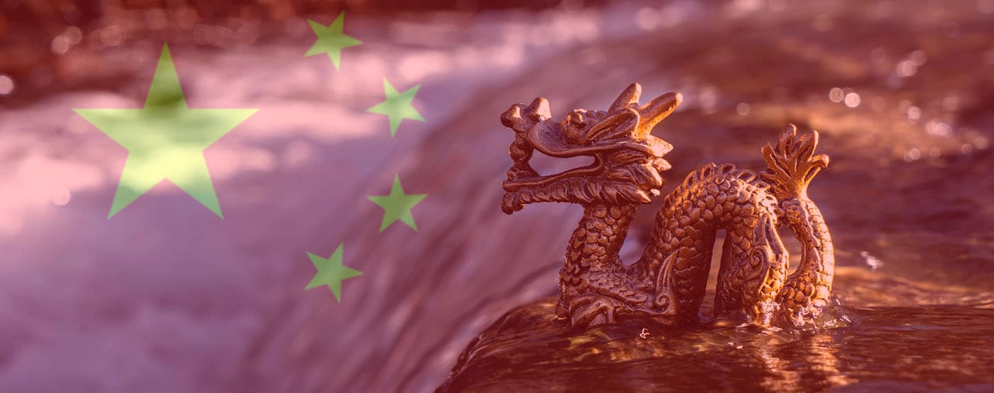 Seguridad de Asia-Pacífico. Estatuilla de un dragón en un río con la bandera de China
