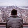La intimidad de la mente. Hombre con camisa gris mirando los edificios de una ciudad durante el día