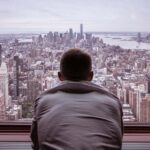 The privacy of the mind. Man in a gray shirt looking at a city buildings during daytime
