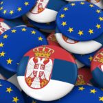 Insignias y pila de botones de la bandera de Serbia y de la Unión Europea. Ilustración 3D