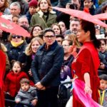 Crowds of people at the Chinese New Year parade in the streets of the Usera neighbourhood, Madrid (Spain). At the front, women dressed in traditional red costumes and umbrellas to welcome the year of the pig