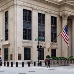 Inflation-financial stability trade-off. People crossing the street at a traffic light in front of the Federal Reserve Bank headquarters building in Chicago, Illinois (US)