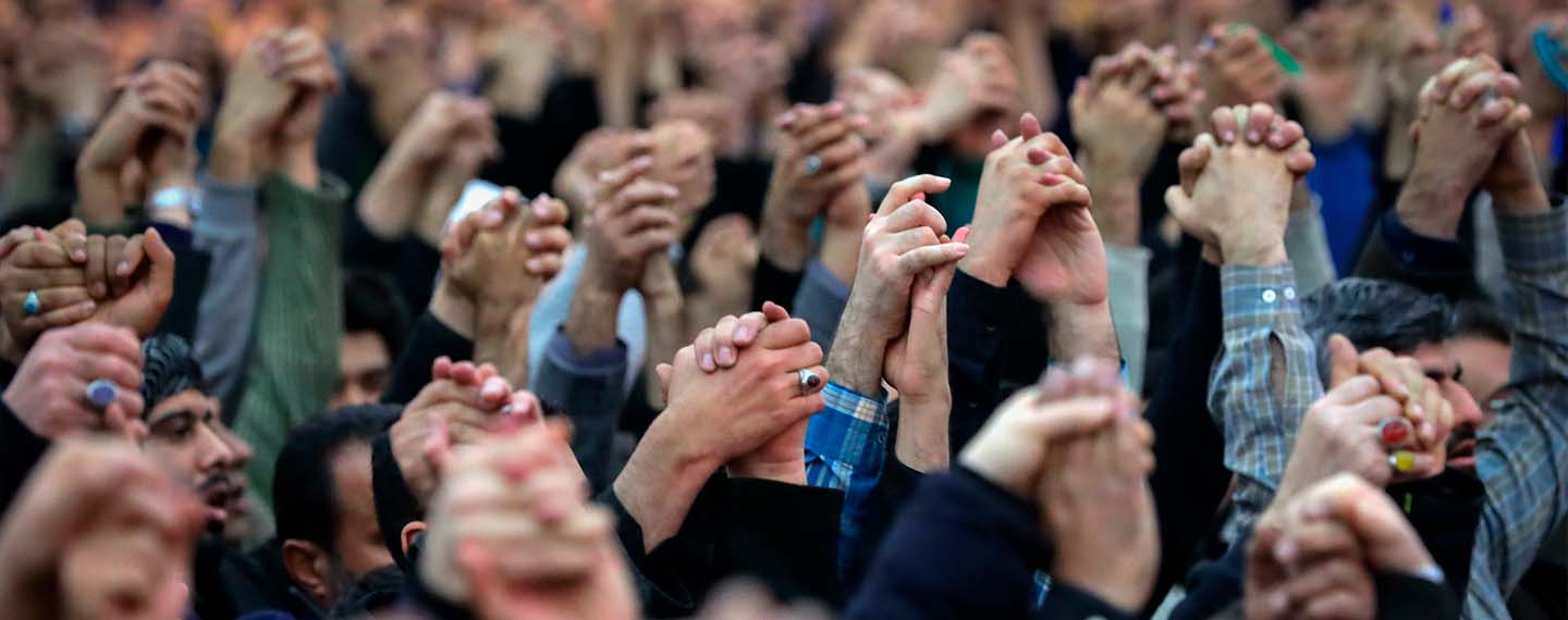 Manos entrelazadas elevadas al cielo de los feligreses durante la oración de los viernes en Teherán, capital de la República Islámica de Irán con el discurso del ayatolá Jamenei