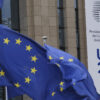 Banderas de la UE y banner con el logo de la Presidencia Española del Consejo de la UE como decoración en el edificio Europa en Bruselas, Bélgica.