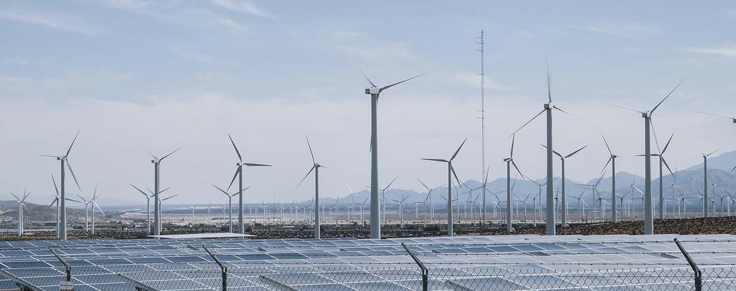 Energy transition. Wind turbines and solar panels during daytime. Solar photovoltaic and onshore wind are the cheapest forms of power generation
