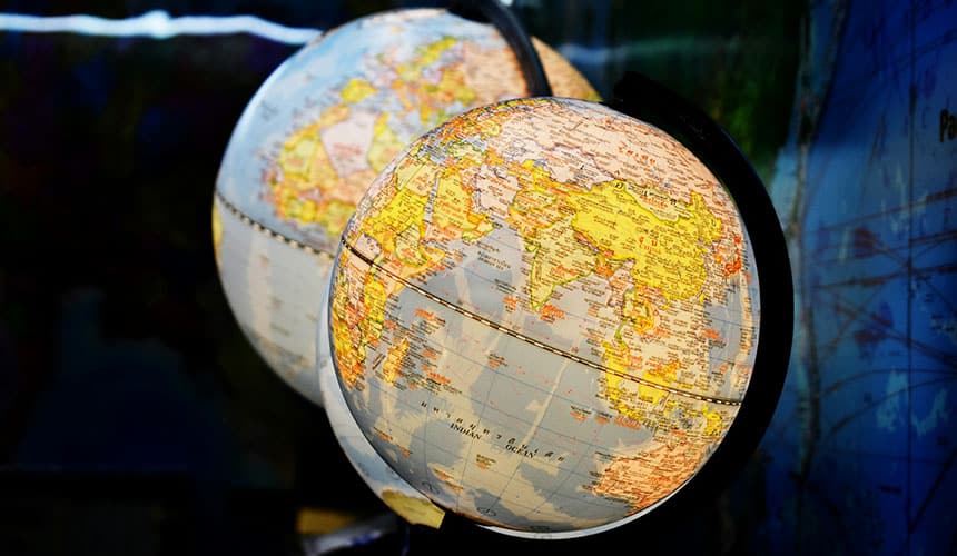 Fotografía de enfoque superficial de dos globos terráqueos de escritorio. En el globo en primer plano se distingue el Océano Índico. Sur global