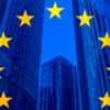 Concepto de política, negocios, finanzas y ampliación de la Unión Europea con la bandera de la UE sobre rascacielos y edificios corporativos de fondo