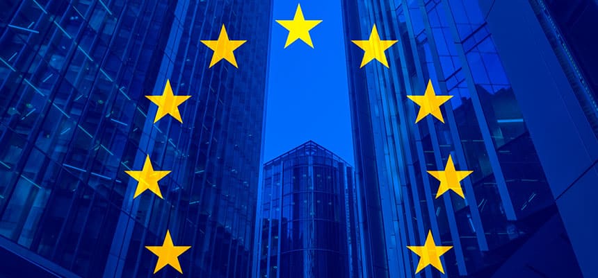 Concepto de política, negocios, finanzas y ampliación de la Unión Europea con la bandera de la UE sobre rascacielos y edificios corporativos de fondo