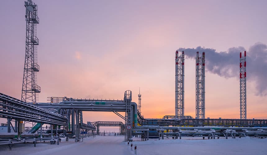 Russian gas production and processing plant near the town of Nov Urengoi. In the foreground a pipeline distribution complex. On the left, a transmission and telecommunications tower, and on the right, three smoke outlet towers