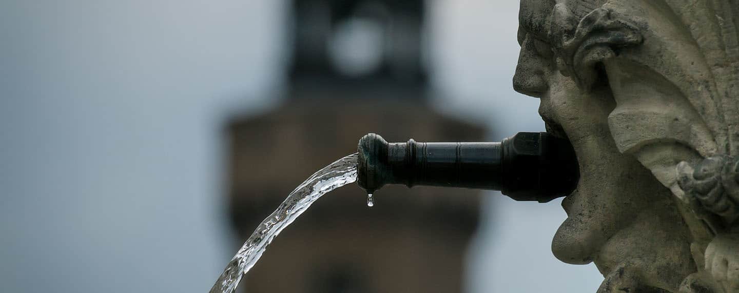 Foto del detalle de la fuente de St. Georg con un chorro de agua. La fuente se encuentra en el casco antiguo de la ciudad de Görlitz en Alemania. Seguridad hídrica