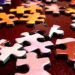 Multicoloured puzzle pieces on a brown table.