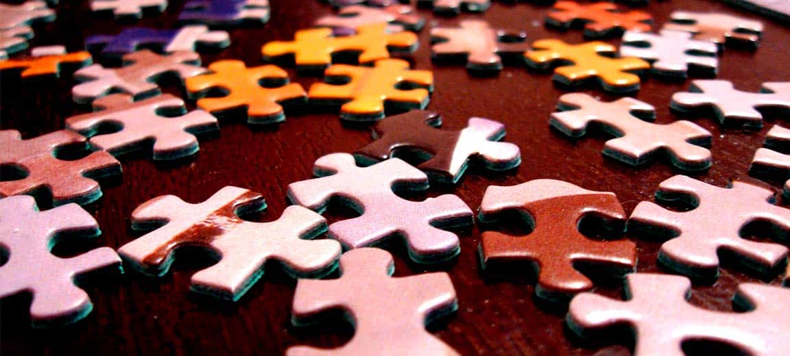 Multicoloured puzzle pieces on a brown table.