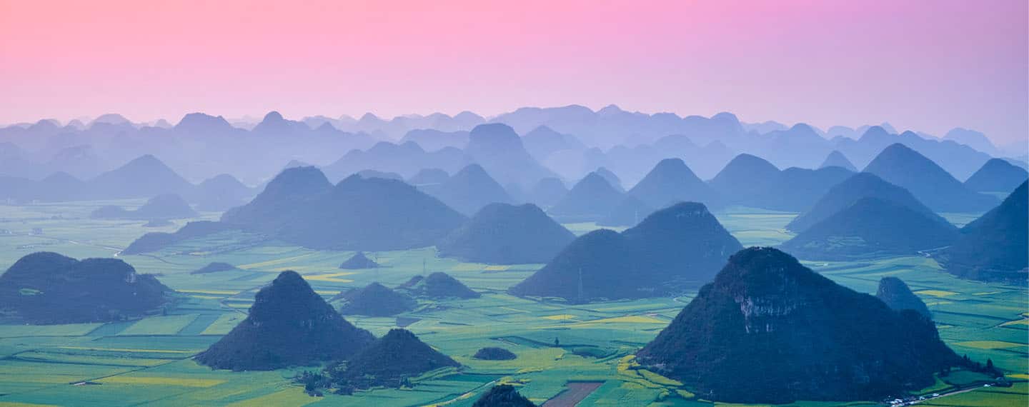 Campos de flores de colza en flor en el condado de Luoping (China) al atardecer.