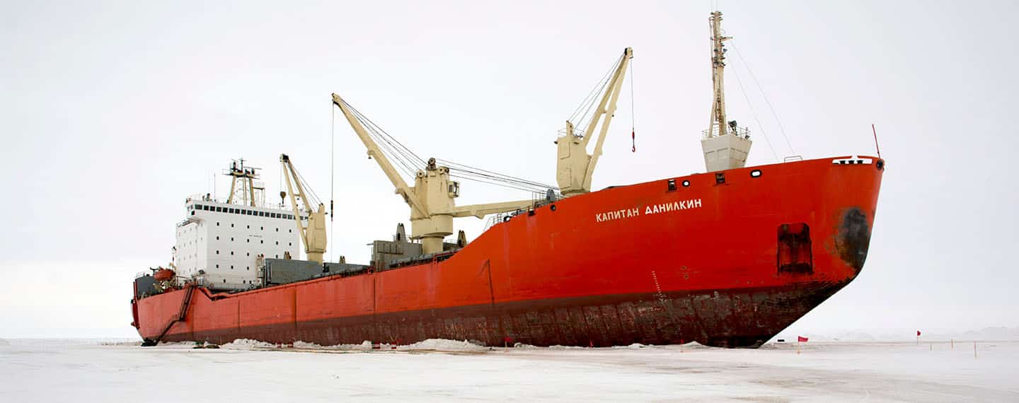 Red Russian icebreaker in the icy waters of the North Pole during the day.