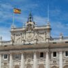 Detail of the façade of the Royal Palace in Madrid with the Spanish flag. King Felipe VI