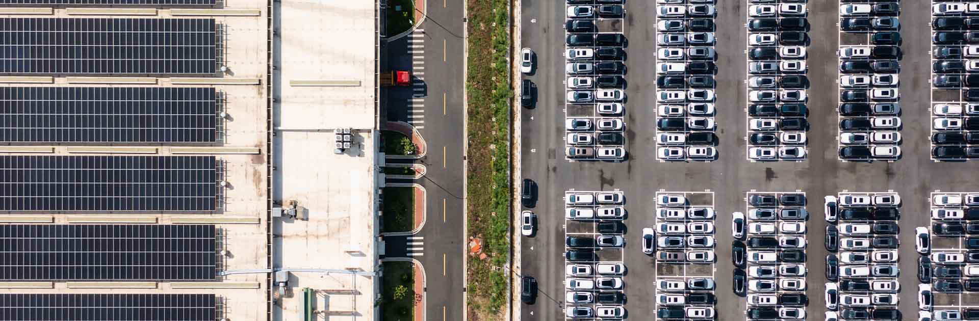 Vista área diurna de un tejado con paneles solares y un aparcamiento para coches eléctricos en China. China a la deriva