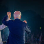 US President Joe Biden, in a navy blue suit, and Vice President Kamala Harris, in a beige suit, in front of a crowd of people during the 4th of July celebration at the White House