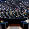 Vista del hemiciclo del Parlamento Europeo con los parlamentarios sentados en sesión. La foto fue tomada desde la puerta en lo alto de una escalera pequeña en una cabina lateral con cristales. Europa
