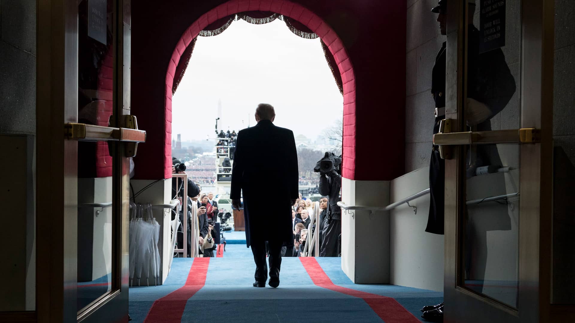 Imagen de espaldas de Donald Trump, con un traje azul marino, caminando hacia su asiento para la ceremonia de investidura en el Capitolio de Estados Unidos en Washington, el viernes 20 de enero de 2017.