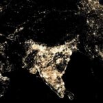 Night-time view of the Asian continent from space, highlighting the urban lights of India and surrounding regions. The light clusters indicate densely populated and developed areas. India