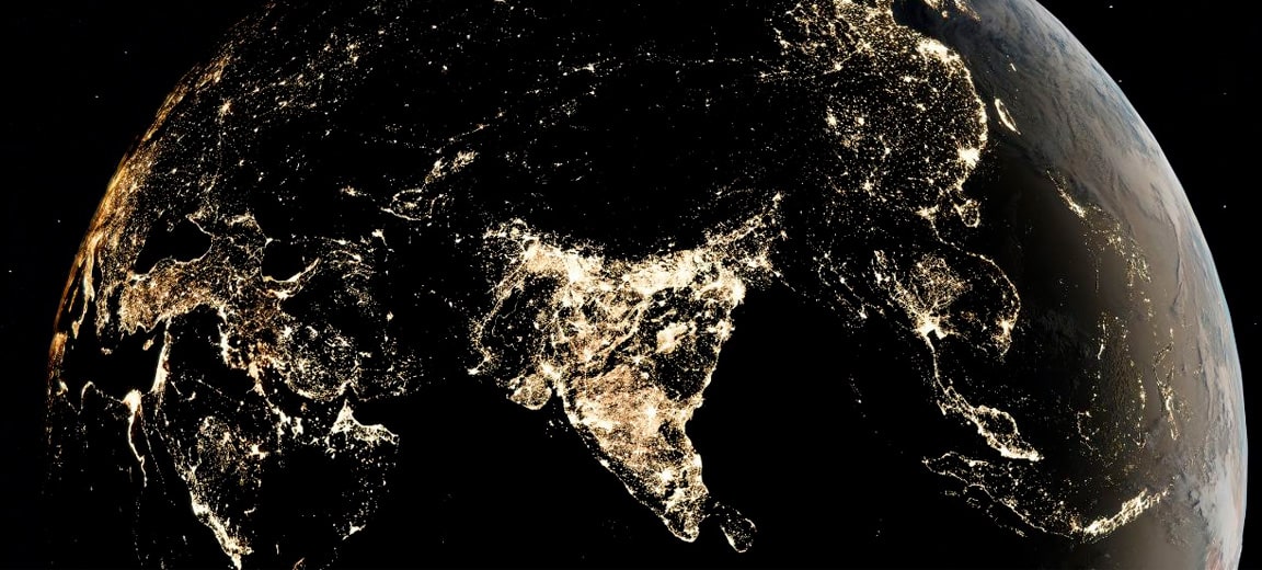 Night-time view of the Asian continent from space, highlighting the urban lights of India and surrounding regions. The light clusters indicate densely populated and developed areas. India