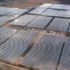 Vista aérea de una gran planta de energía solar térmica situada en la provincia de Granada (España). En primer plano, se muestran extensas filas de espejos parabólicos que reflejan la luz del sol, con una pequeña zona de infraestructura en el centro, rodeada de un paisaje árido. Draghi
