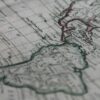Detalle de un mapa histórico del continente americano, con tonos tierra y contorno en verde y rojo. Latinobarómetro