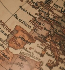 Primer plano de un globo terráqueo clásico, centrado en Europa y las regiones circundantes, con nombres de ciudades y países visibles. Unión Europea
