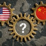 Three golden interlocking gears over a map of Europe on a dark textured background. The left gear features the US flag, the right gear shows the Chinese flag, and the bottom gear features a white question mark.