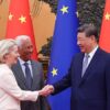 Ursula von der Leyen, presidenta de la Comisión Europea (a la izquierda) estrechando manos con Xi Jinping, presidente de China (a la derecha), mientras los observa Antonio Costa, presidente del Consejo Europeo (al lado de von der Leyen) durante la Cumbre UE-China en Pekín (24 de julio de 2025). Al fondo, las banderas de la Unión Europea (azules con estrellas amarillas) y de China (rojas con estrellas amarillas).