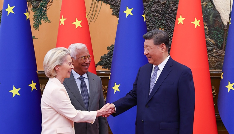 Ursula von der Leyen, presidenta de la Comisión Europea (a la izquierda) estrechando manos con Xi Jinping, presidente de China (a la derecha), mientras los observa Antonio Costa, presidente del Consejo Europeo (al lado de von der Leyen) durante la Cumbre UE-China en Pekín (24 de julio de 2025). Al fondo, las banderas de la Unión Europea (azules con estrellas amarillas) y de China (rojas con estrellas amarillas).