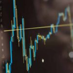 Primer plano de un monitor con gráficos financieros en azul y amarillo. Impuestos