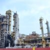 El Palito oil refinery in Puerto Cabello (Carabobo State, Venezuela). The image shows multiple oil distillation towers, furnaces and many interconnected piping systems for processing. In the background, the sky is clear with a few clouds.
