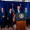 Donald Trump at the press conference following ‘Operation Absolute Resolution’ in Venezuela and the capture of Nicolás Maduro (3/01/2026) in Mar-a-Lago, Florida. The president speaks behind the lectern, adorned with the president's logo and a microphone. Behind him, from left to right, are Stephen Miller, National Security Advisor; John Ratcliffe, Director of the CIA; Marco Rubio, Secretary of State; Pete Hegseth, Secretary of War; and General Dan Caine, Chairman of the Joint Chiefs of Staff. Behind them are the flags of the United States and the Presidency, and a blue and white backdrop.