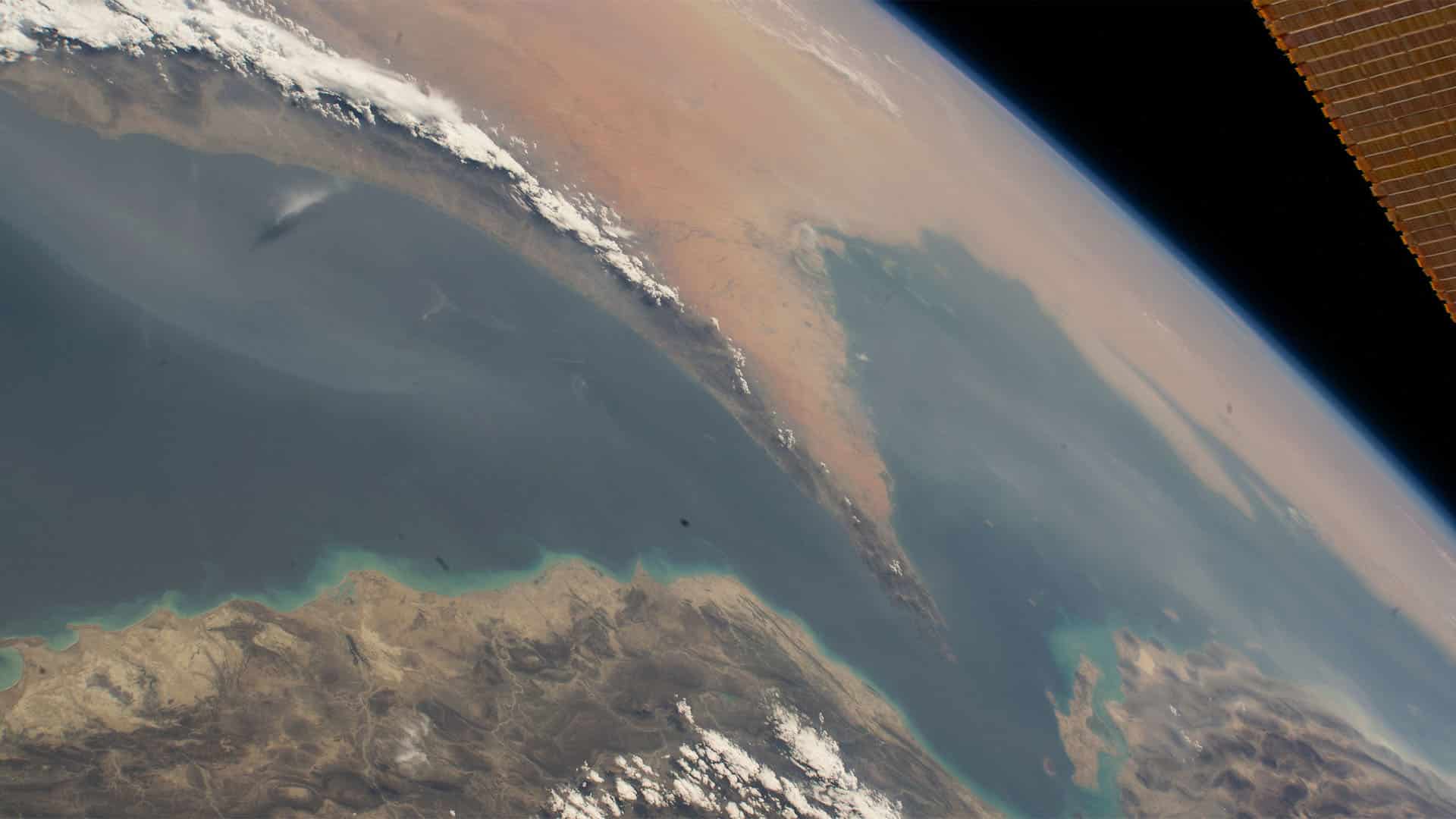 Imagen satelital del estrecho de Ormuz, entre el golfo Pérsico y el golfo de Omán, que separa Irán (al norte) de la península arábiga (al sur), captada desde un satélite, donde se observan las diferentes texturas y colores del mar y la tierra, y algunas nubes.