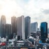 El skyline de los edificios del distrito financiero de Shinjuku destaca entre el resto de los edificios comerciales y de viviendas. Los rascacielos enmarcan un cielo claro aunque muy nublado.