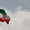 Bandera de Irán en un cielo nublado.