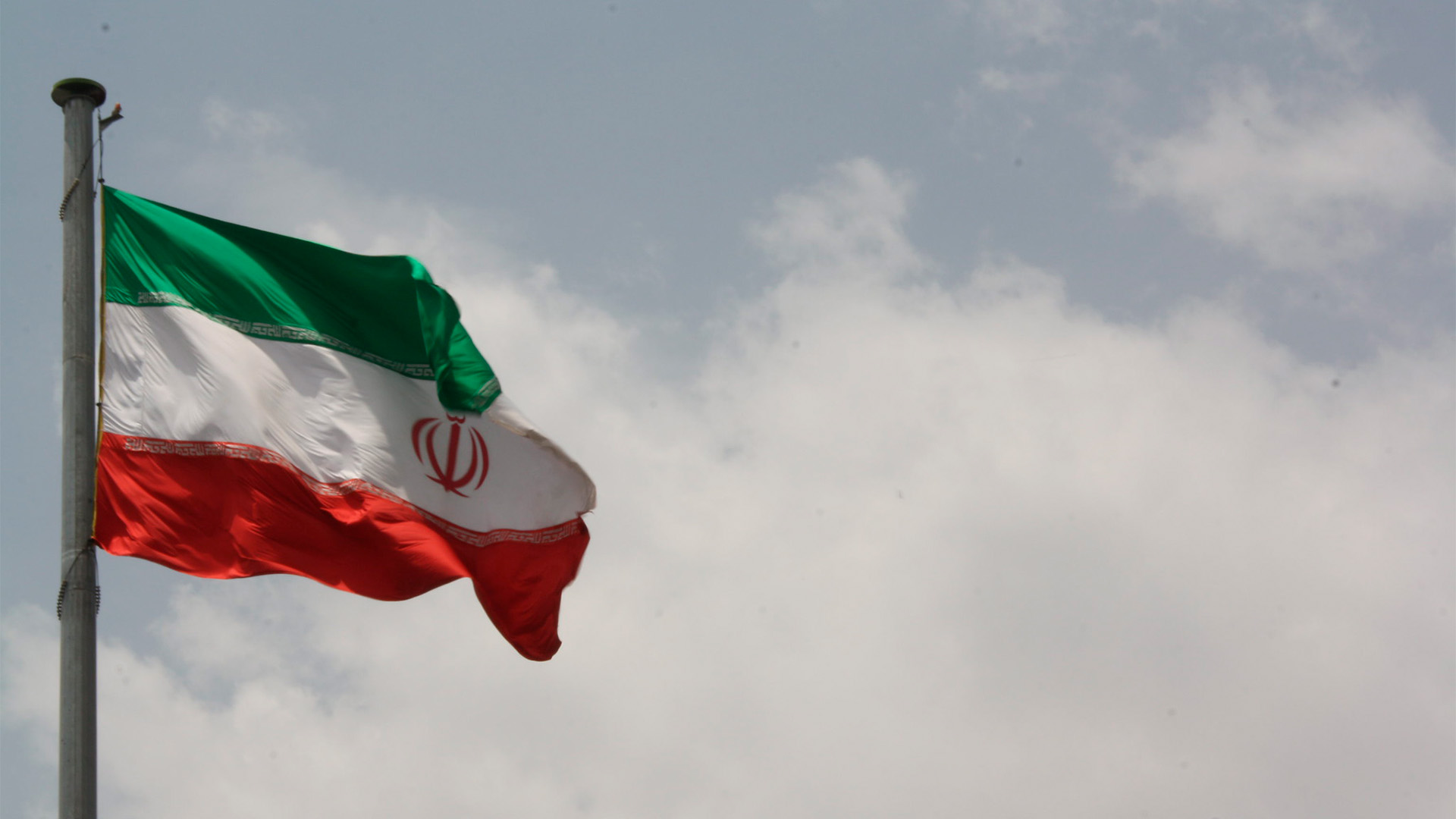 Bandera de Irán en un cielo nublado.